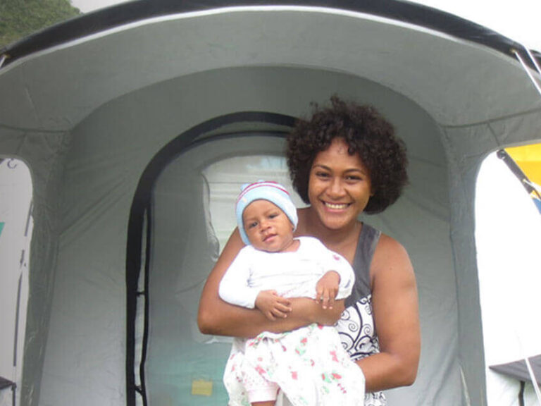 Mother and child in front of tent.