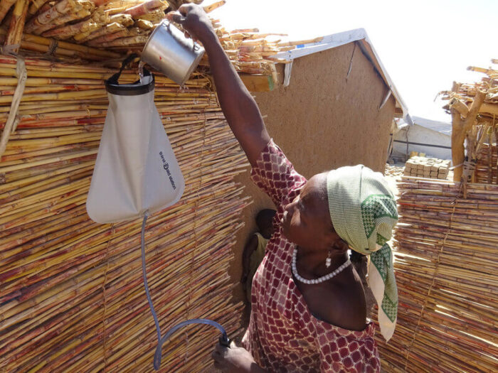 Woman using a water filter to clean dirty water