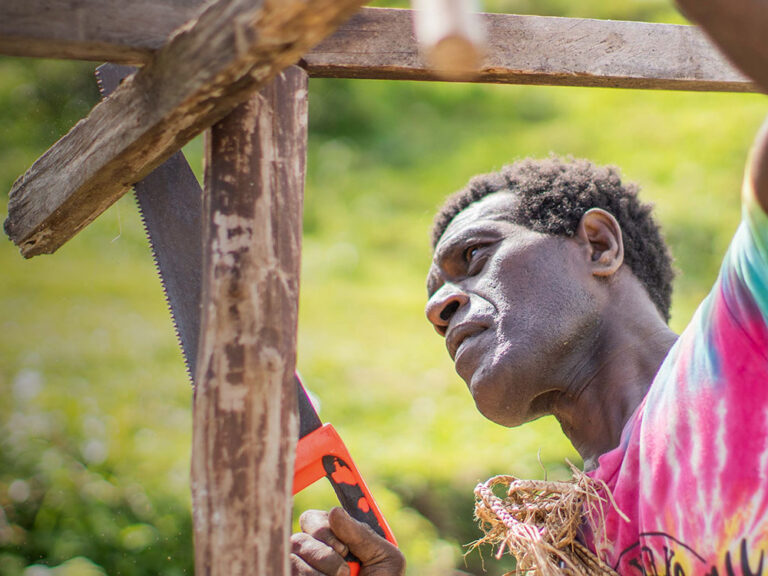 man building shelter after cyclone