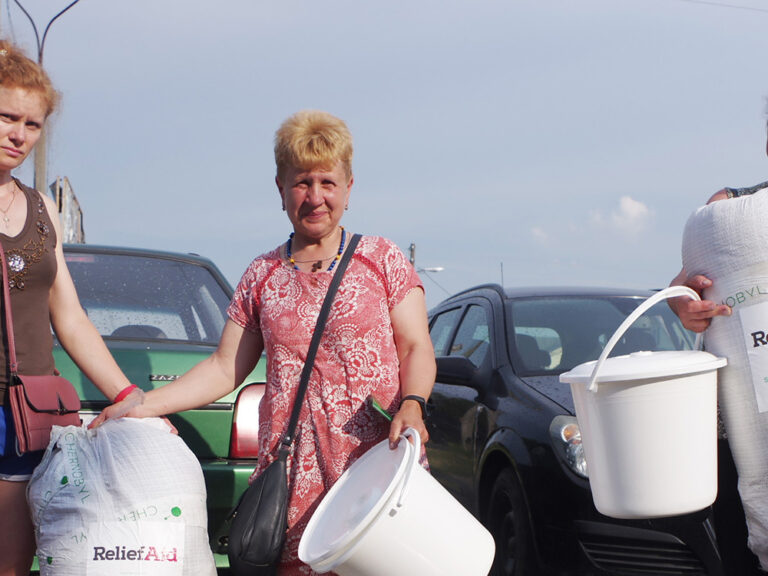 Three women holding aid collected in Ukraine