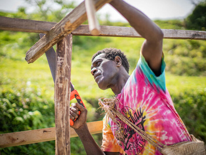 Man rebuilding support of a shelter after extreme storm Cyclone Harold