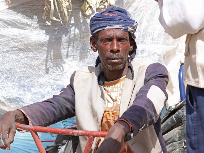 Man sitting on a scooter inside a displacement camp in Yemen