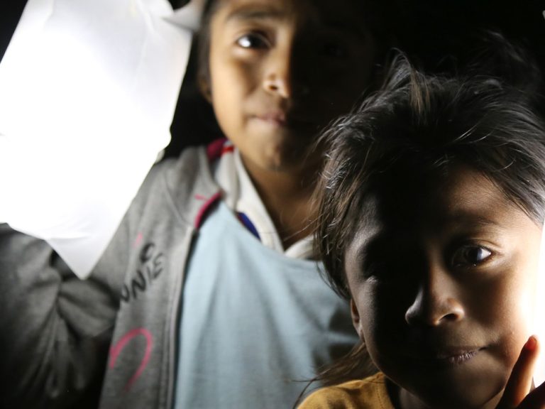 Two children holding solar lights